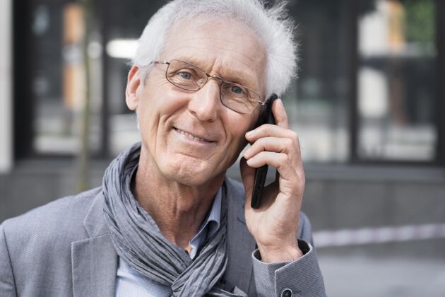 移动城里的一个老男人在用智能手机聊天老年人老年人讲电话