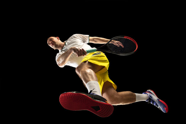 个人年轻的白种人网球运动员在比赛中 动作孤立在黑墙上 从底部看运动的概念 运动 活力和活力 健康的生活方式训练 练习男封闭健身