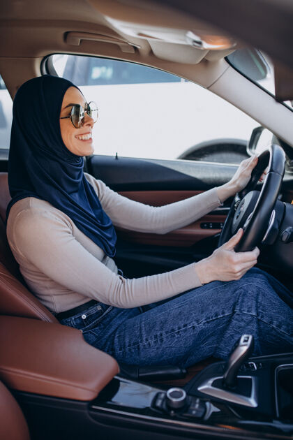 传统年轻的现代妇女开车中间头巾文化
