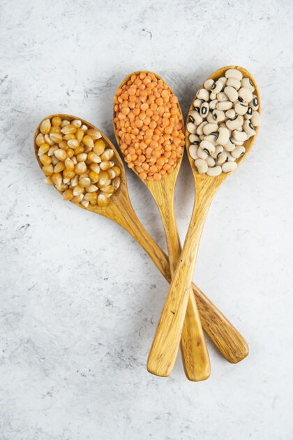 玉米大理石表面放着各种豆和玉米的木勺仁豆类谷物