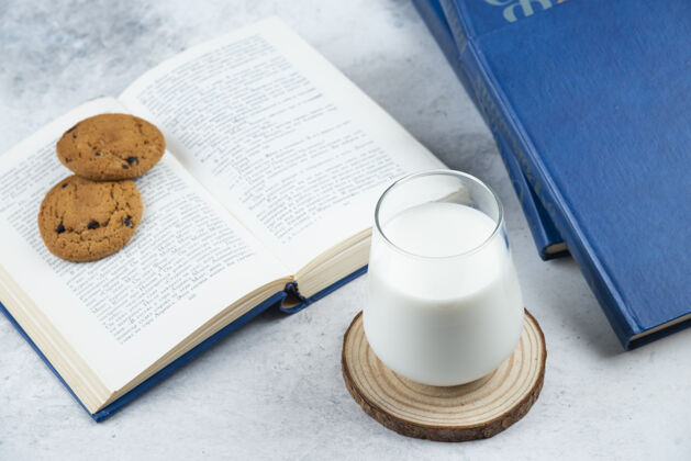 牛奶一杯冷牛奶加巧克力饼干和书食物巧克力饼干