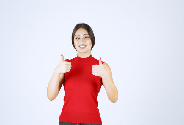 成功穿红衬衫的女孩展示着快乐的手势休闲员工服装