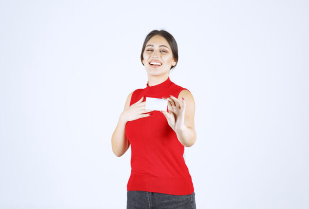 女人穿着红衬衫的女孩拿着一张名片展示自己人休闲工人