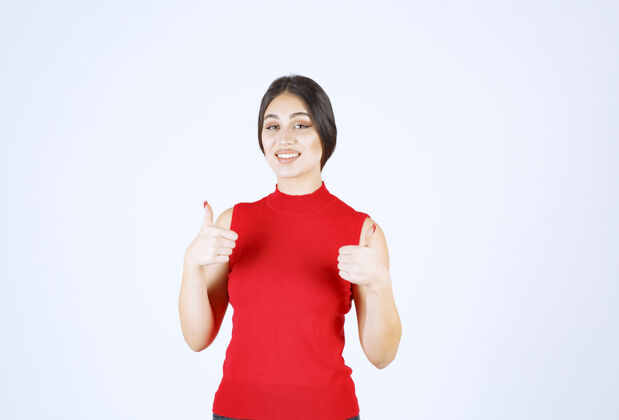 雇员穿红衬衫的女孩竖起大拇指年轻人员工工人
