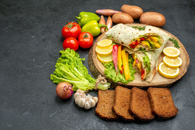 新鲜前视图切片美味的沙玛肉三明治与面包和蔬菜在黑暗的空间饮食西红柿一餐