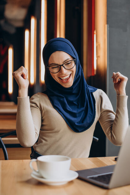 在咖啡馆里用电脑上网的年轻女青年女性伊斯兰情感