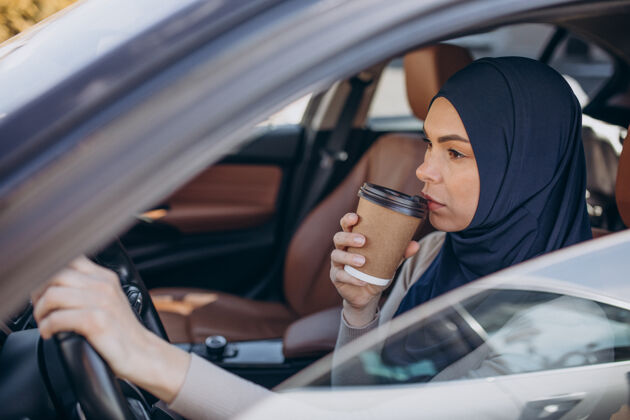 车辆年轻的现代妇女在车里喝咖啡种族表情宗教