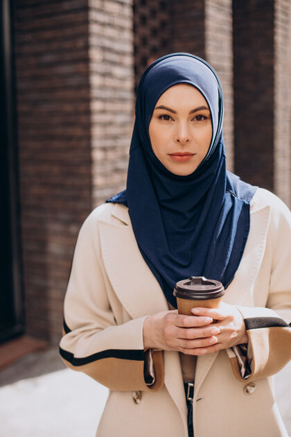 学生年轻的妇女在喝咖啡围巾头巾