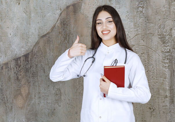 医疗保健年轻的女医生一边拿着书一边竖起大拇指医学预防病毒