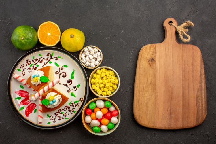新鲜俯瞰美味的派片与糖果和新鲜的橘子在黑暗的背景蛋糕甜饼干派水果饼干视图陶瓷器皿