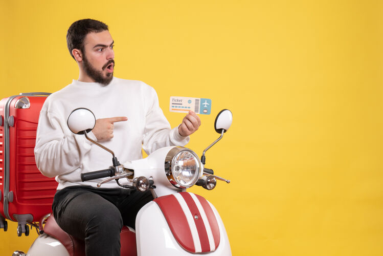 运动员旅行概念与惊讶的男子坐在摩托车上 手提箱上显示黄色的车票比赛旅行高尔夫