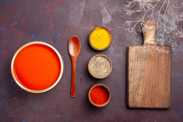 创意俯瞰美味的西红柿汤 用新鲜西红柿和调味料烹制而成 背景为深红色的西红柿汤刷子新鲜汤