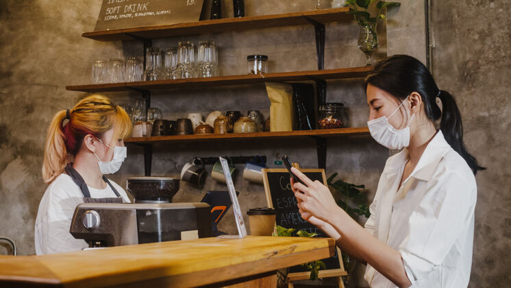 距离年轻女性戴口罩自助餐厅使用手机支付非接触面具年轻食品