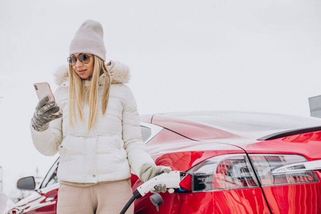 替代性女人充电红色电动车 在冬天的时候成功电力车辆