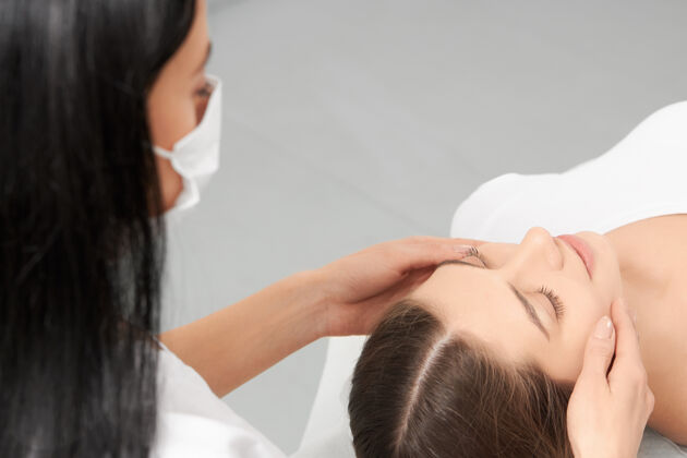 女人美容师用化妆品做脸部按摩专业治疗脸