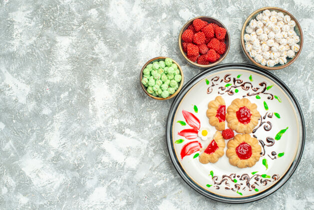 蛋糕俯瞰美味的饼干与红色果冻和糖果的白色背景饼干蛋糕饼干甜胡椒粉顶部食物