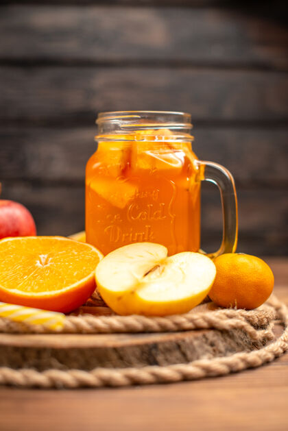 板有机新鲜果汁在一个瓶子里的垂直视图 里面有管子 水果放在砧板和棕色的木桌上水果服务木材