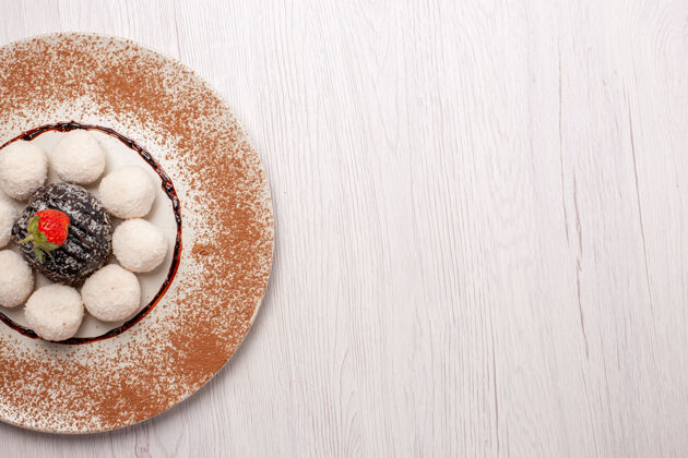 封闭俯瞰美味的椰子糖 白色桌面上有巧克力蛋糕糖蛋糕饼干糖果饼干桌子早餐食物