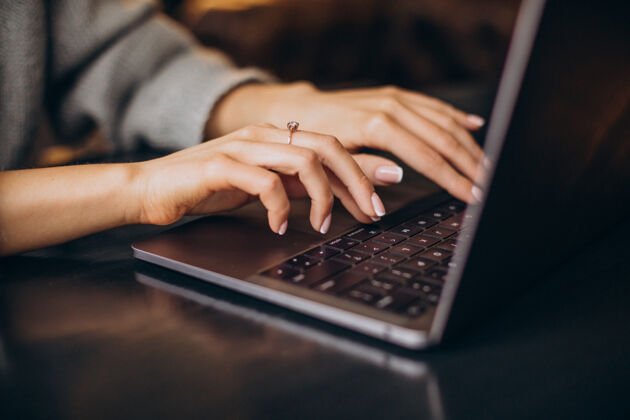 咖啡女性的手在电脑键盘上打字办公桌打字自由职业者