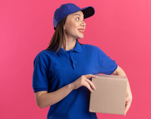 漂亮一个穿着制服的漂亮女送货员拿着名片盒 看着旁边粉色印象持有