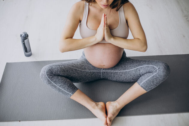 分娩孕妇在家里的垫子上练习瑜伽垫子生活锻炼