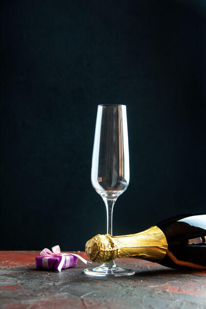 庆典正面是一瓶香槟酒 酒杯背景为深色背景酒杯水晶