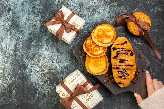 顶部美味的早餐俯视图 薄饼 烤面包 饼干 漂亮的礼品盒摆放在黑暗的表面上早餐堆栈甜点