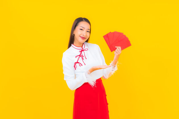 女士肖像美丽的亚洲年轻女子与红包信在中国新年的黄色普通话红包华丽