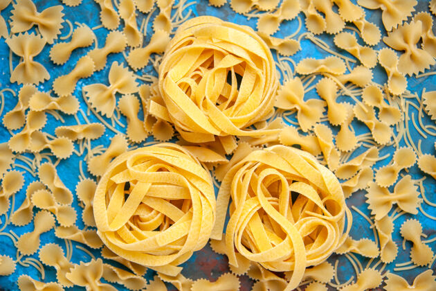 食物在蓝色背景上 意大利面排成一排 晚餐准备的特写镜头玫瑰晚餐意大利面