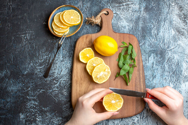 食物俯瞰图一个手切新鲜柠檬和薄荷在一个木制砧板上暗背景薄荷柑橘头顶