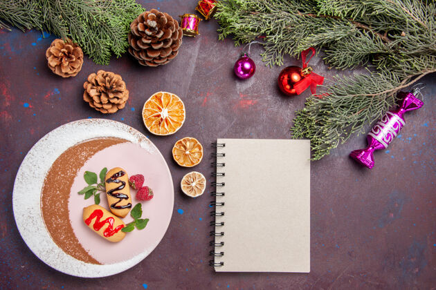 顶部俯瞰美味的甜饼干与圣诞玩具和树上的深色背景饼干甜饼干糖蛋糕景观玩具食物