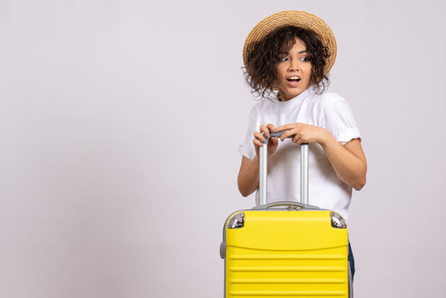 年轻女性正面图年轻女性带着黄包准备在白色背景上旅行旅游度假飞机航行彩色休息休息包飞行