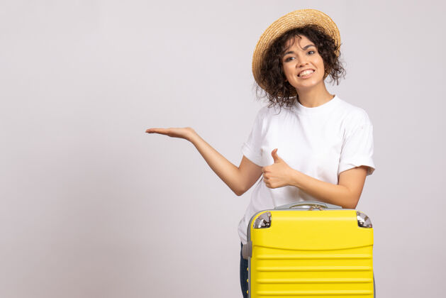 包正面图年轻女性带着黄色的包准备乘坐白色背景的航班休息航行旅游度假彩色飞机晒太阳成人航行休息