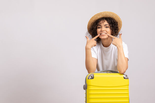 包正面图年轻女性带着黄色的包准备乘坐白色背景色的航班航行飞机晒太阳休息旅游者帽子年轻女性人