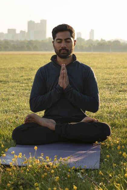 冥想男人在瑜伽垫上冥想的正面图心灵活动草
