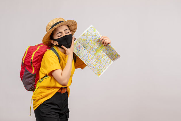 地图疲惫的年轻女子背着红色的背包 举着灰色的地图人成人保护套