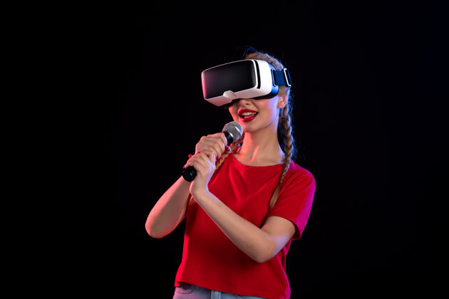 虚拟现实年轻女子在黑暗的墙上玩vr和唱歌的画像人物游戏肖像