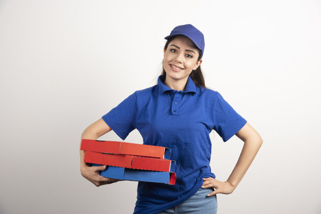 工作年轻的女信使拿着一纸板披萨和剪贴板盒子人披萨