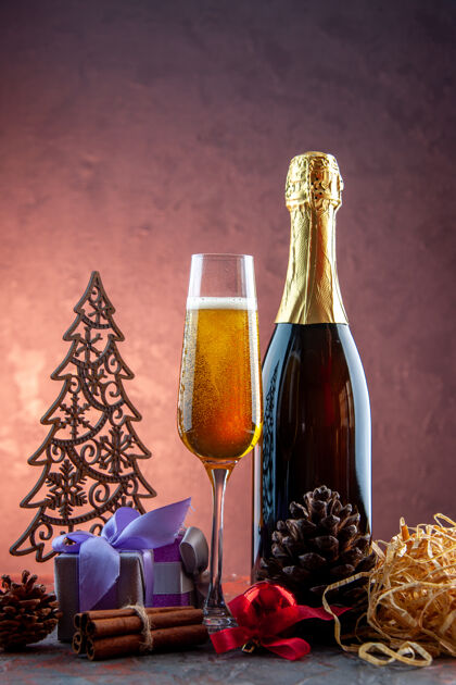 酒精带礼物和酒瓶的香槟酒杯前视图 轻饮酒精照片彩色香槟新年礼物灯容器