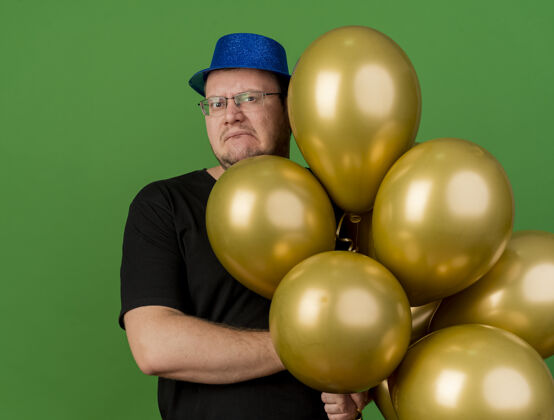 空间戴着眼镜 头戴蓝色派对帽 手持氦气球的未获释成年斯拉夫男子气球光学帽子