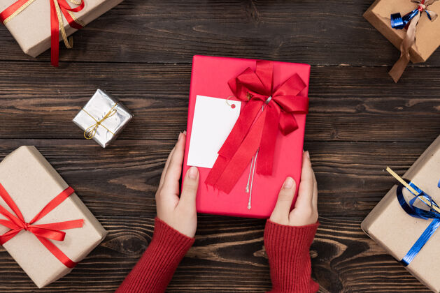 包装在白色的桌面上 女性手拿着一个小盒子 盒子里放着一件礼物生日 圣诞节或婚礼的平铺作文闪光木板礼物