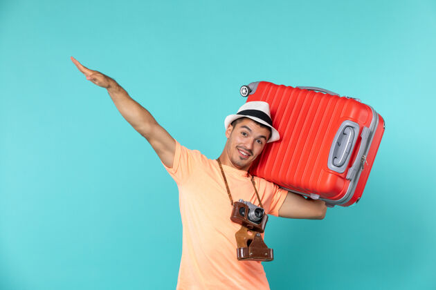 旅行度假的男人拿着蓝色的大红色手提箱包蓝色旅行