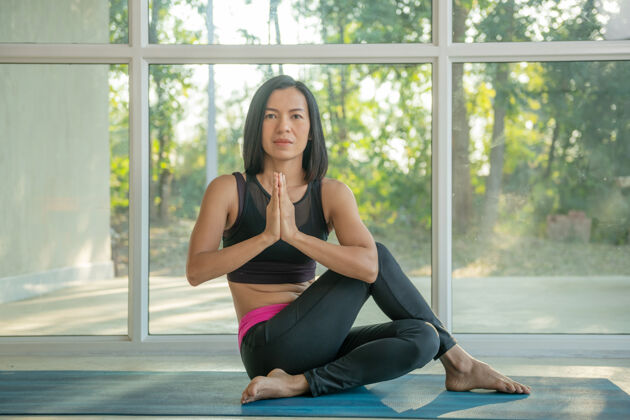 力量年轻迷人的女士在家练习瑜伽 阿达·马西恩德纳摆出一副纳马斯特的姿势 锻炼身体 穿着运动服 裤子和上衣 室内全长 瑜伽工作室运动活跃锻炼
