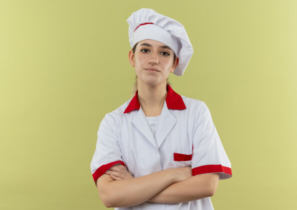 站立自信的年轻漂亮厨师身着厨师制服 站在绿色墙壁上 封闭的姿势与复制空间隔离漂亮厨师封闭