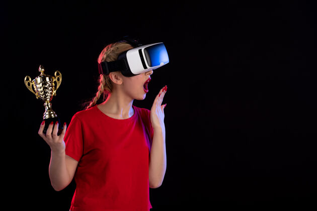 游戏在黑暗的墙壁上 年轻女性正在玩虚拟现实和冠军杯视图游戏年轻女性
