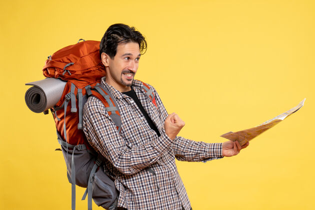 背包正面图：年轻男性带着背包徒步旅行 手持黄色背景地图 旅行航空公司校园森林色彩肖像成人徒步旅行