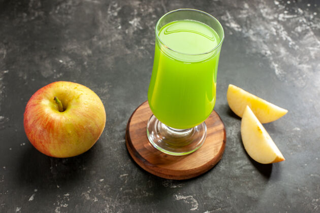 早餐前视图新鲜成熟的苹果与绿色的苹果汁对黑暗醇厚的果汁照片的颜色苹果茶正面