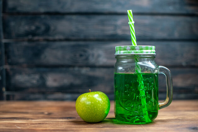 水果正面图绿色苹果汁内罐 木质桌上有新鲜的绿色苹果饮料照片鸡尾酒吧水果色前面柠檬柑橘