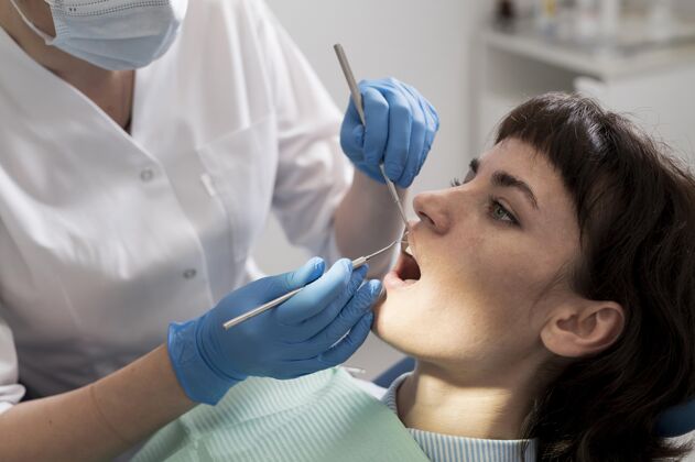 医疗年轻的女病人在正畸医生那里做牙科手术职业水平女性