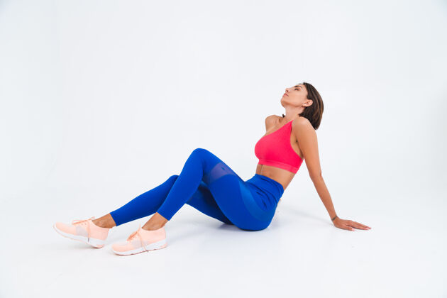 腹肌适合皮肤黝黑的运动型女性 拥有腹肌 健康曲线 穿着上衣和白色蓝色紧身裤女士女性锻炼